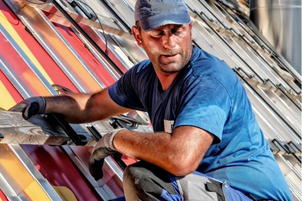 man aan het werk op het dat - BEDON adviseert technische installatie bedrijven op het gebied van arbozorg